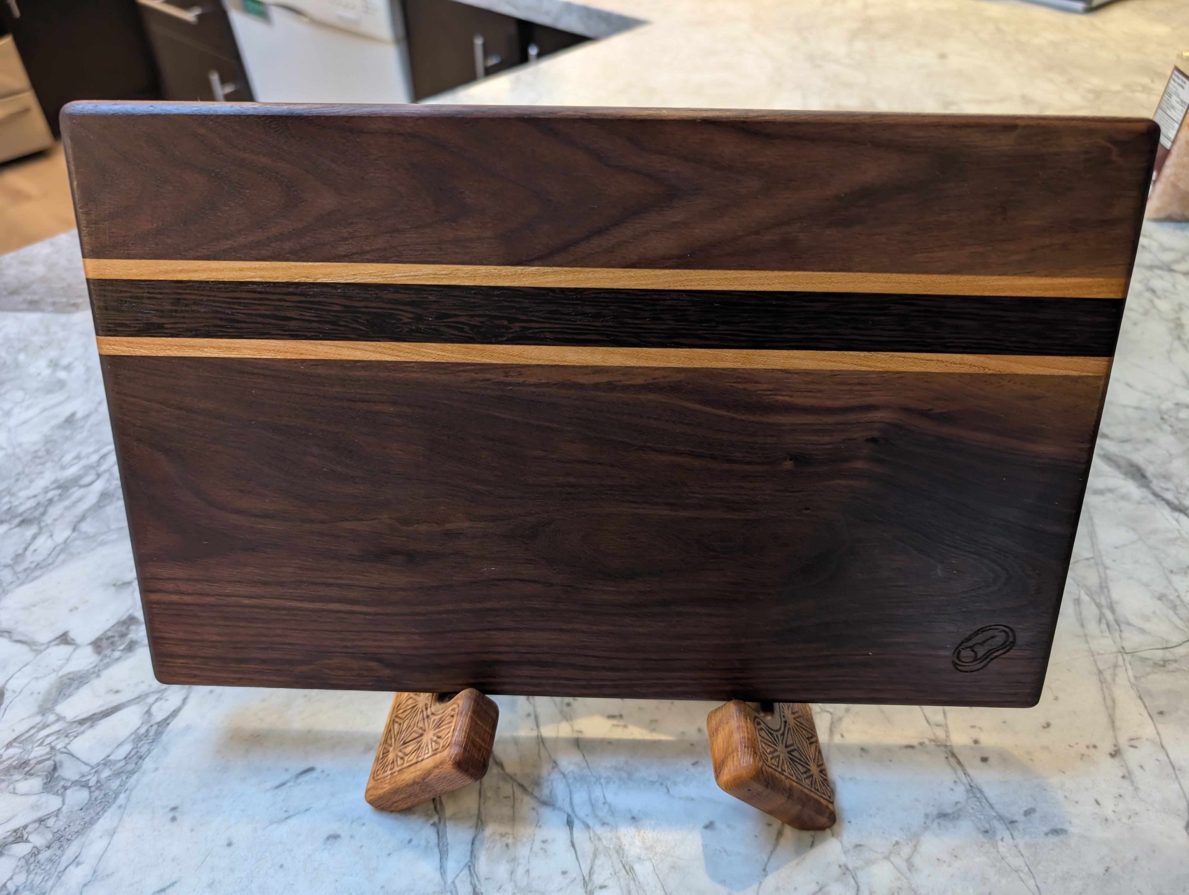 Striped walnut cutting board on display stand