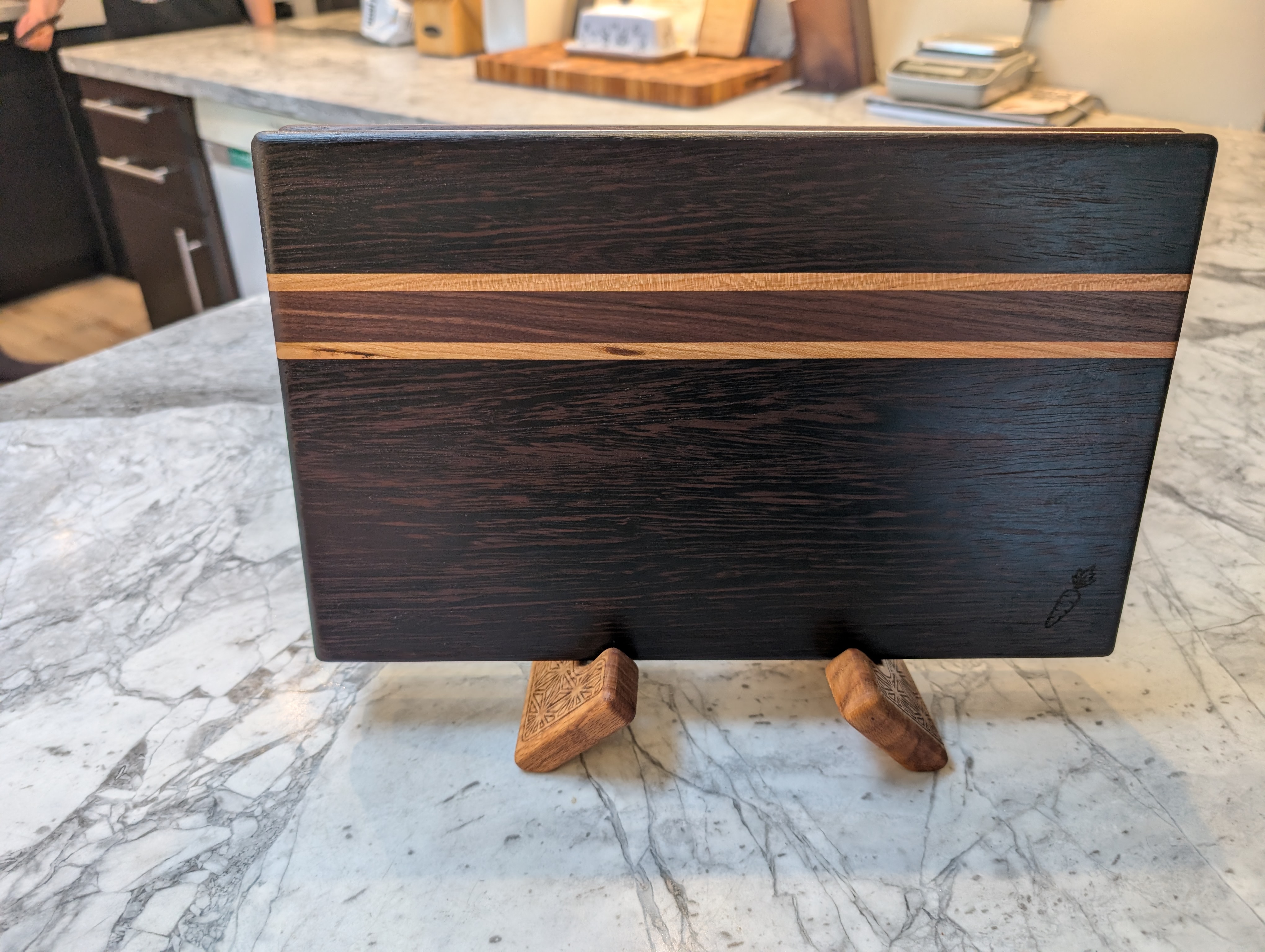 Striped wenge cutting board on display stand